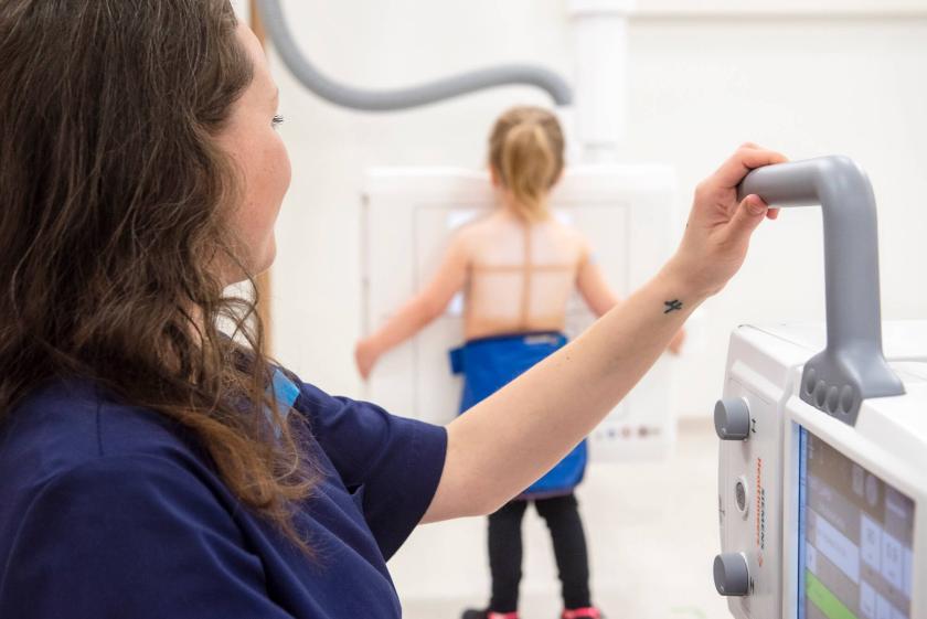 A nurse taking a chest X-ray of a child.