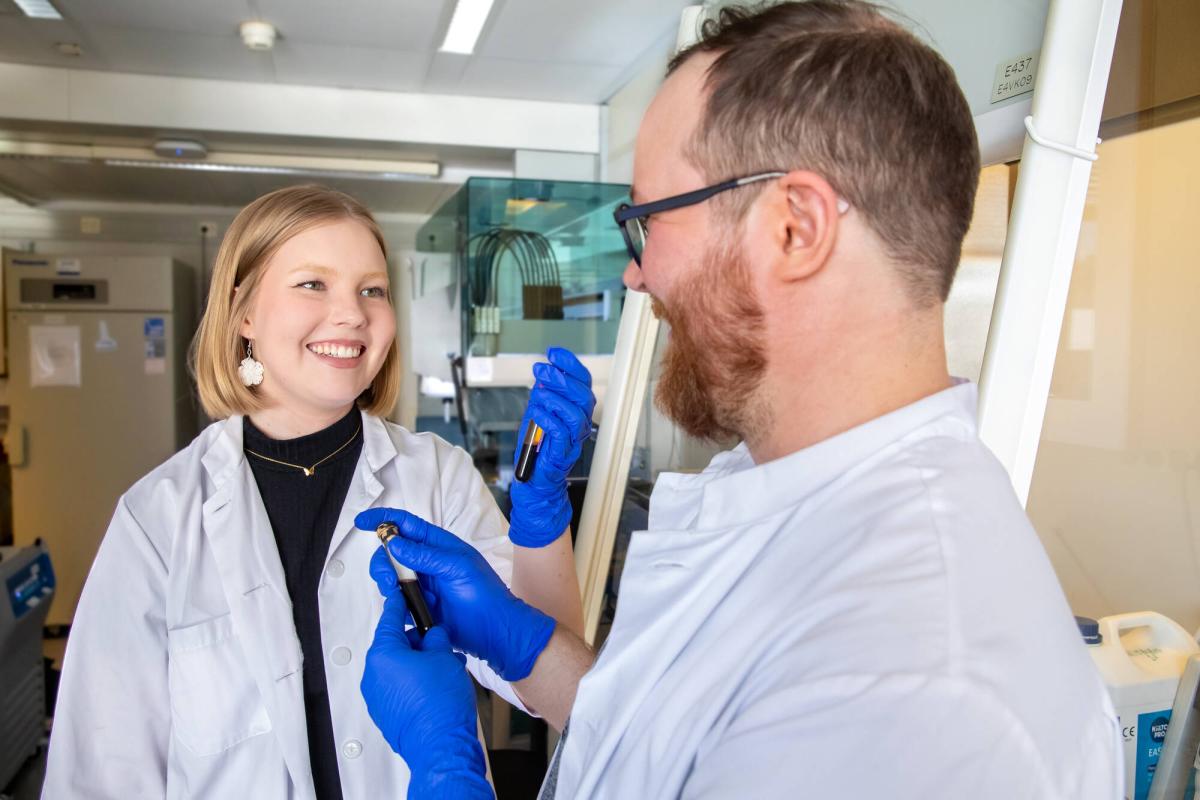 Två forskare i ett laboratorium. Forskarna håller provrör i sina händer.