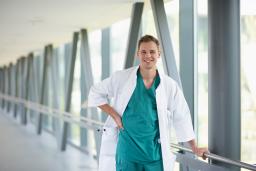 Vatsakirurgiaan erikoistuva lääkäri hymyilee Jorvin sairaalan käytävällä